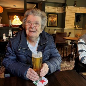 Care home resident drinking beer in pub