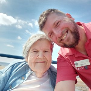 Care home resident and caregiver at the beach